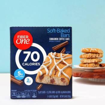 A box of Fiber One 70 calorie Cinnamon Coffee Cake Soft-baked Bars. A stack of unwrapped bars sits on a plate in the background. - Link to social post